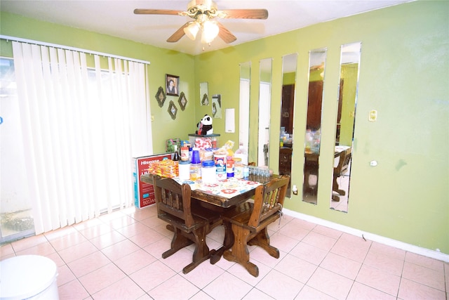 dining space with light tile patterned flooring, a ceiling fan, and baseboards