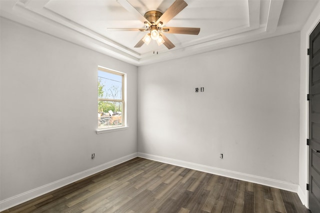 spare room with dark hardwood / wood-style floors, a raised ceiling, and ceiling fan