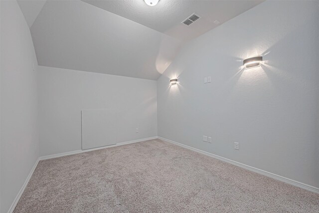 bonus room with vaulted ceiling and carpet