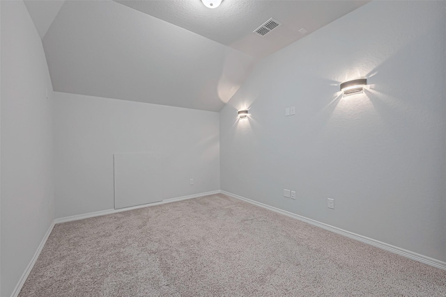 additional living space with carpet flooring and lofted ceiling