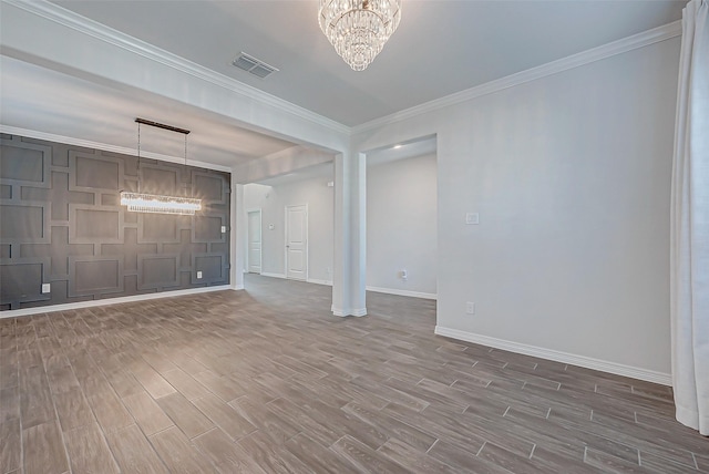 spare room featuring crown molding and an inviting chandelier