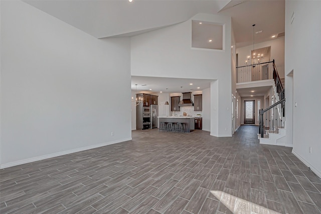 unfurnished living room featuring dark hardwood / wood-style flooring and a notable chandelier