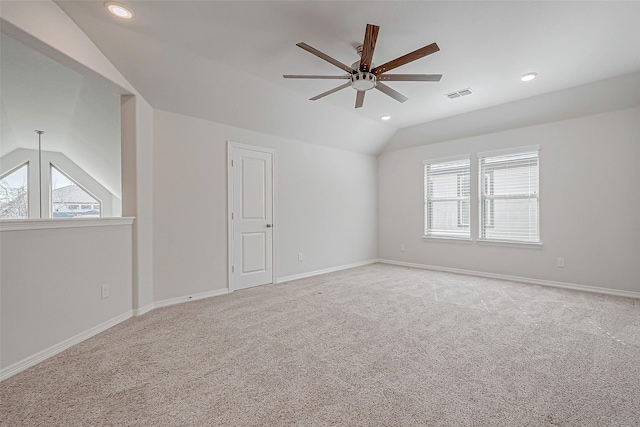 carpeted spare room featuring ceiling fan and lofted ceiling