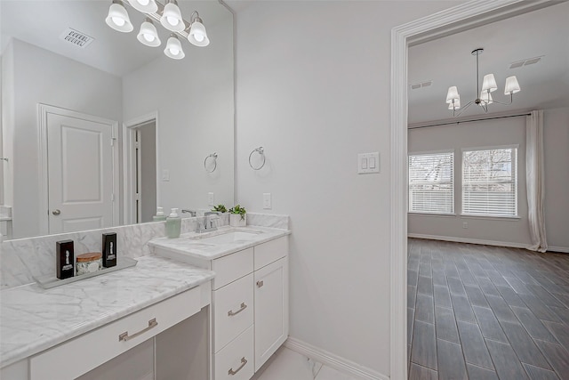 bathroom with a notable chandelier and vanity