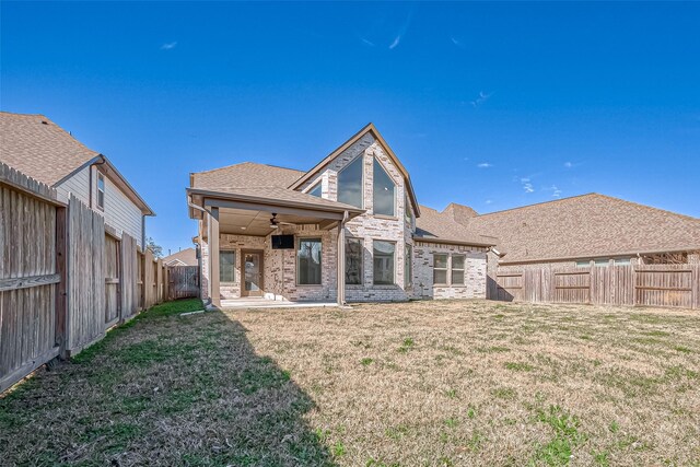 back of property featuring a yard, ceiling fan, and a patio area