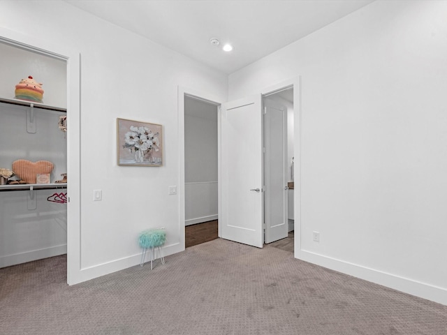 unfurnished bedroom with light colored carpet and a closet