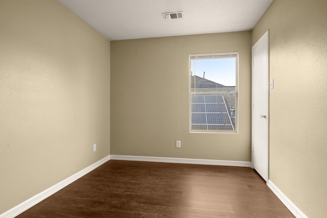 empty room featuring dark hardwood / wood-style flooring