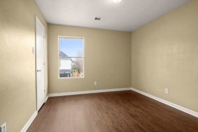 spare room featuring dark hardwood / wood-style flooring