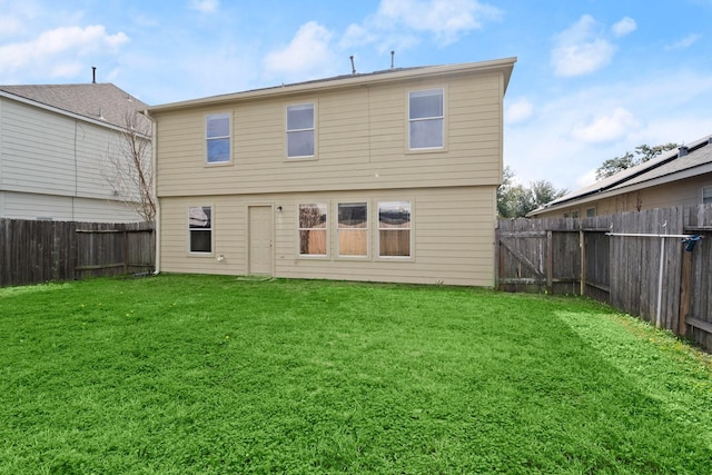 rear view of house featuring a lawn