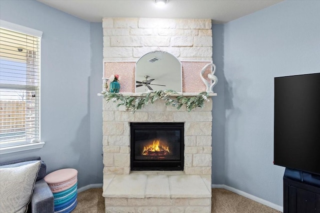 living room featuring a stone fireplace and carpet flooring