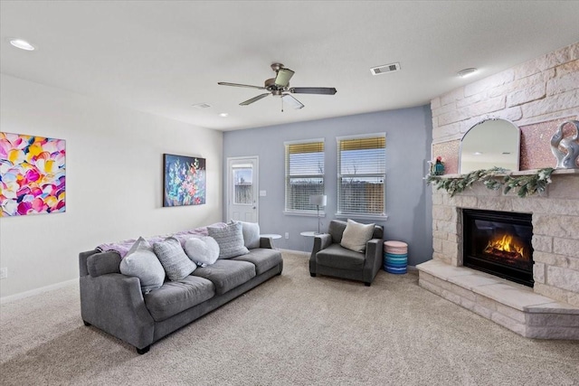 living room featuring ceiling fan, a fireplace, and carpet floors