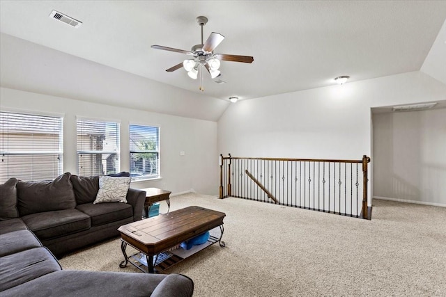 carpeted living room with ceiling fan and vaulted ceiling