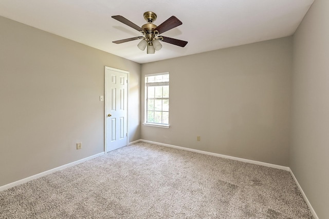 carpeted spare room featuring ceiling fan