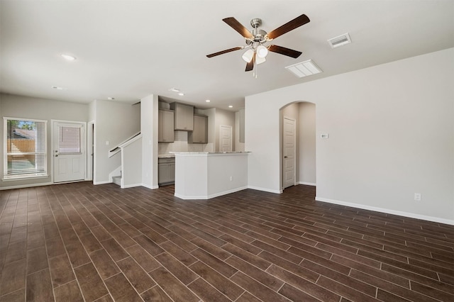 unfurnished living room with dark hardwood / wood-style floors and ceiling fan