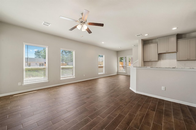 kitchen featuring dark hardwood / wood-style flooring, decorative backsplash, gray cabinets, and plenty of natural light