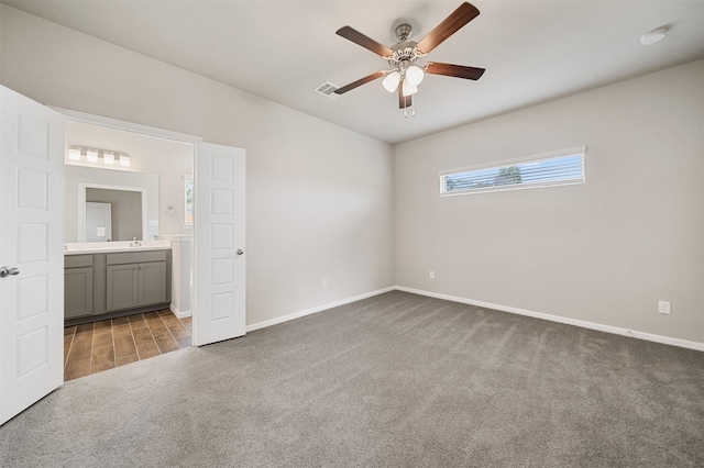 unfurnished bedroom featuring connected bathroom, carpet floors, sink, and ceiling fan