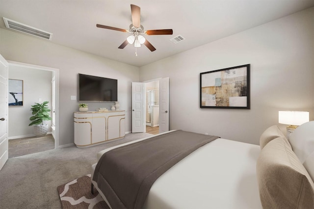 carpeted bedroom with ensuite bathroom and ceiling fan