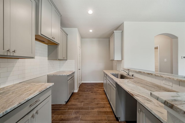 kitchen with gray cabinetry, sink, and backsplash