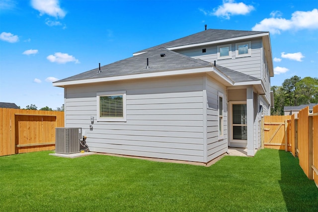 back of house featuring a yard and cooling unit