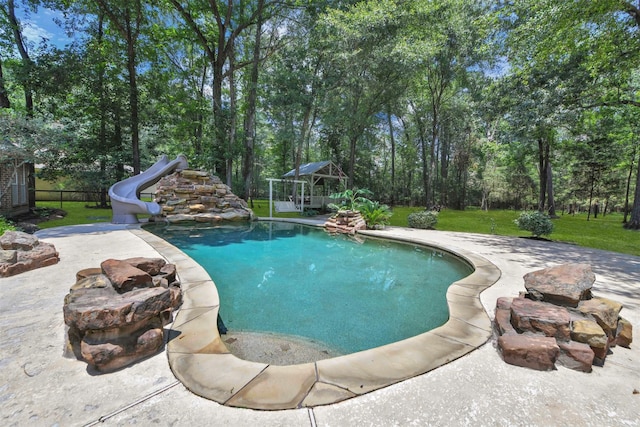 view of swimming pool with a water slide, a patio area, and a lawn