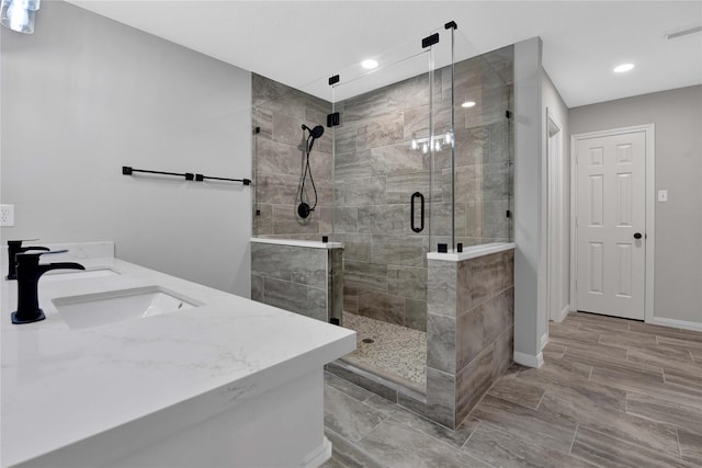 bathroom with vanity and a shower with door