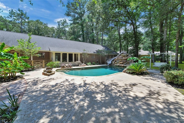 view of pool with a water slide and a patio