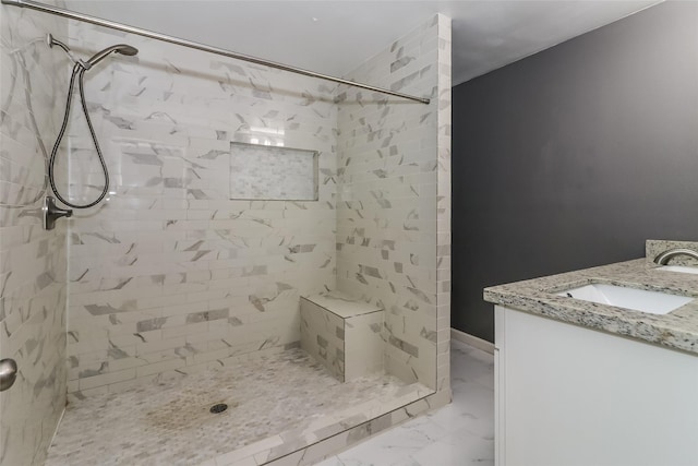 bathroom with tiled shower and vanity