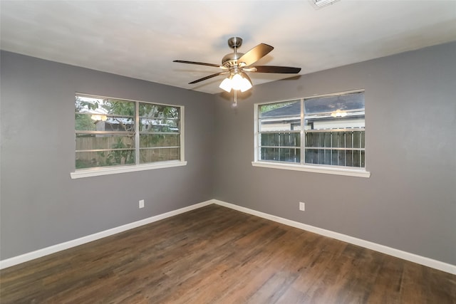 empty room with ceiling fan and dark hardwood / wood-style flooring