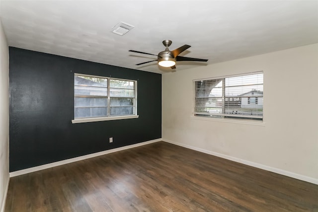 spare room with dark wood-type flooring and ceiling fan