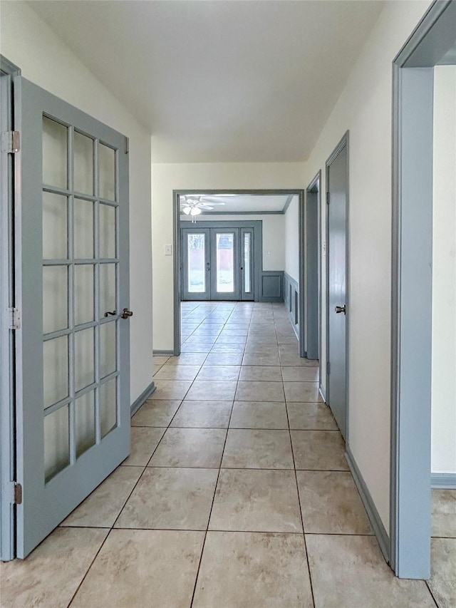 corridor with light tile patterned floors and french doors