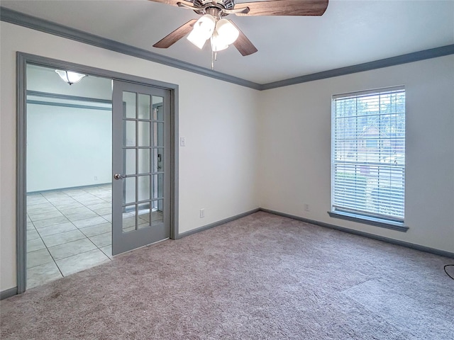 spare room featuring crown molding, ceiling fan, light carpet, and french doors