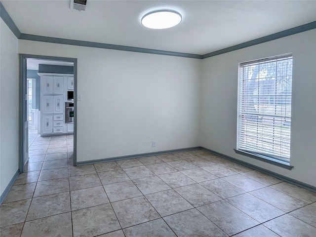 tiled empty room featuring ornamental molding