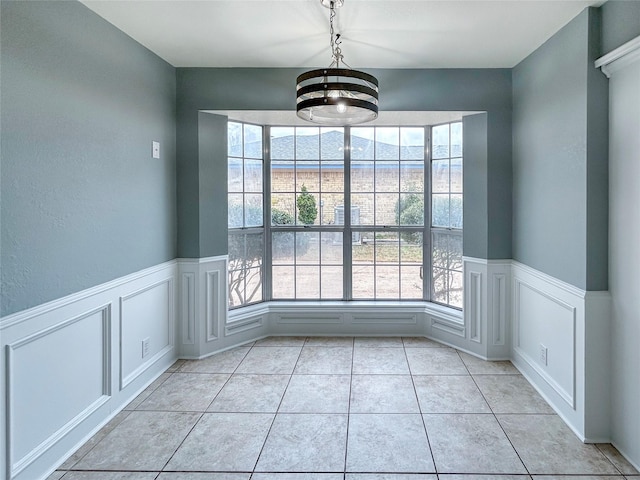 unfurnished dining area featuring light tile patterned flooring and plenty of natural light