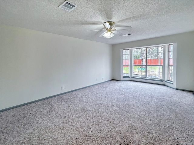 spare room with ceiling fan, carpet, and a textured ceiling