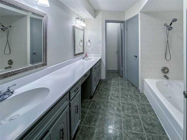 bathroom with vanity, tiled shower / bath combo, and a textured ceiling