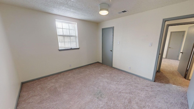 unfurnished bedroom featuring light colored carpet and a textured ceiling