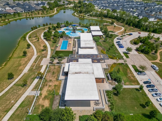 aerial view of property and surrounding area featuring a pool area and a large body of water