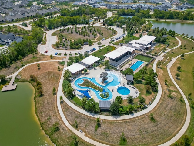aerial view of property and surrounding area with a pool and a nearby body of water