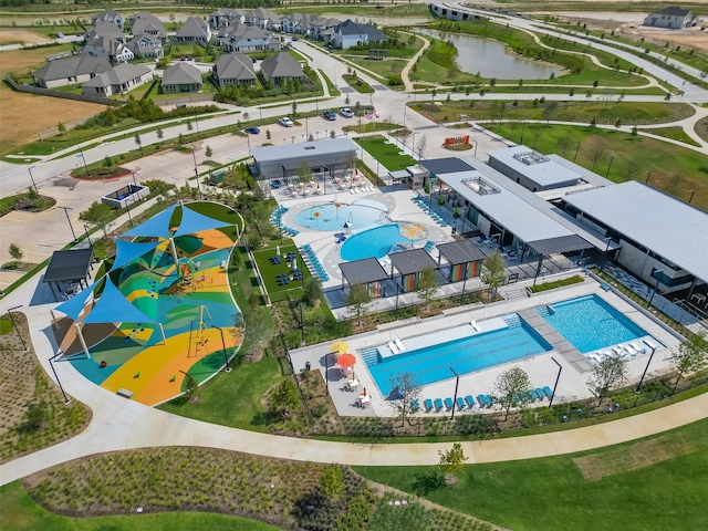 drone / aerial view of a pool and a large body of water