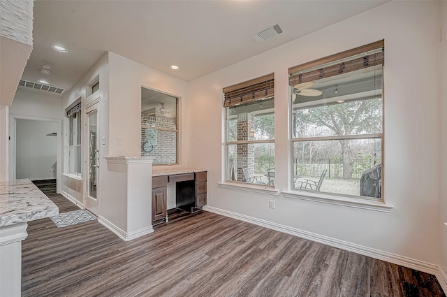 unfurnished living room with dark wood-style flooring, baseboards, and recessed lighting