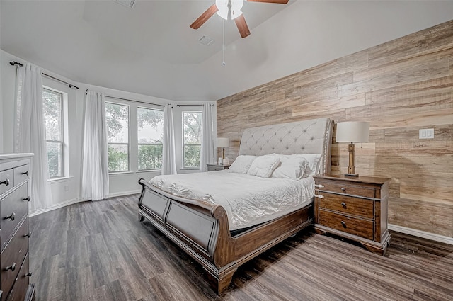 bedroom featuring wood finished floors, baseboards, wooden walls, and a ceiling fan