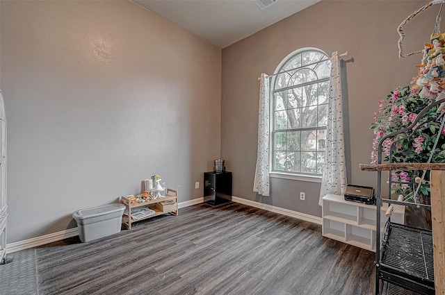 misc room featuring wood finished floors, healthy amount of natural light, and baseboards