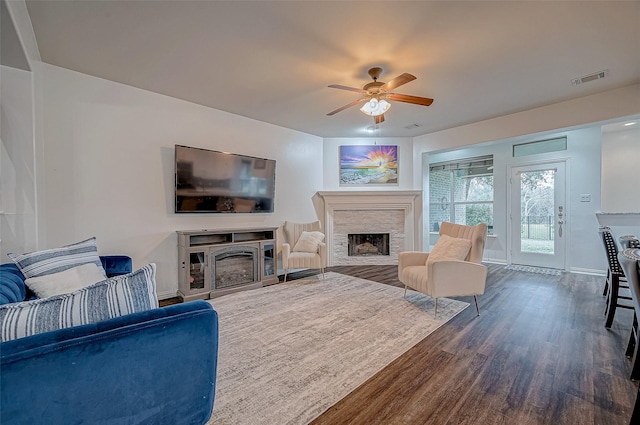 living room with a fireplace, dark wood-style flooring, ceiling fan, and baseboards