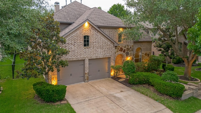 view of front of house with brick siding, a chimney, concrete driveway, an attached garage, and a shingled roof