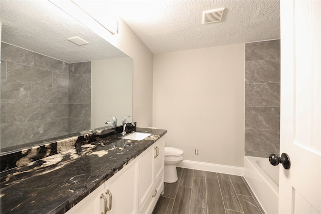 full bathroom featuring shower / bath combination, vanity, a textured ceiling, and toilet