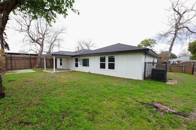 214 Canadian St, Houston, TX 77009 - back of property featuring board and batten siding, a fenced backyard, a lawn, and a patio area