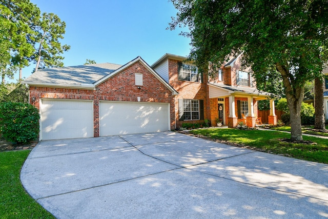 view of front property with a garage, covered porch, and a front lawn