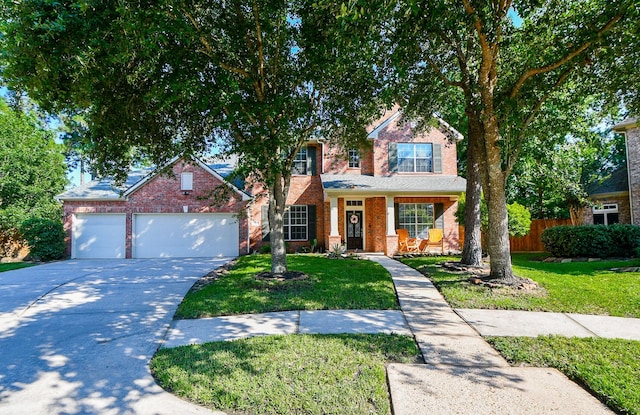 view of property with a garage, covered porch, and a front lawn