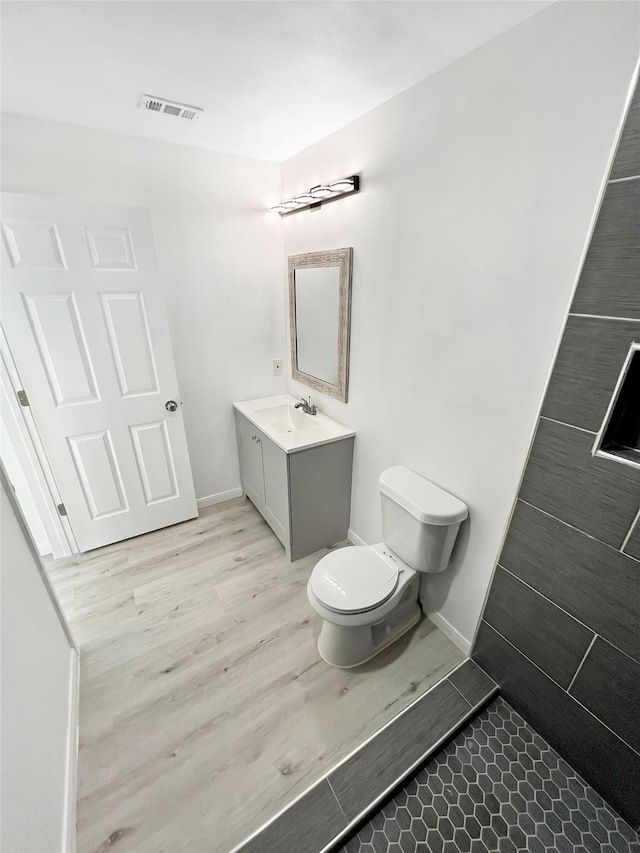 bathroom featuring vanity, hardwood / wood-style flooring, and toilet