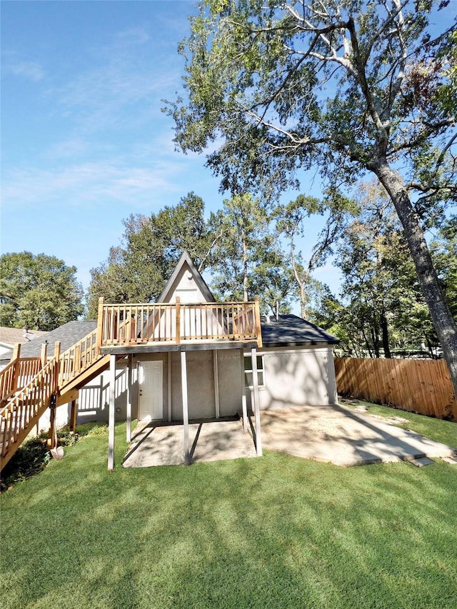 back of house featuring a wooden deck, a yard, and a patio area